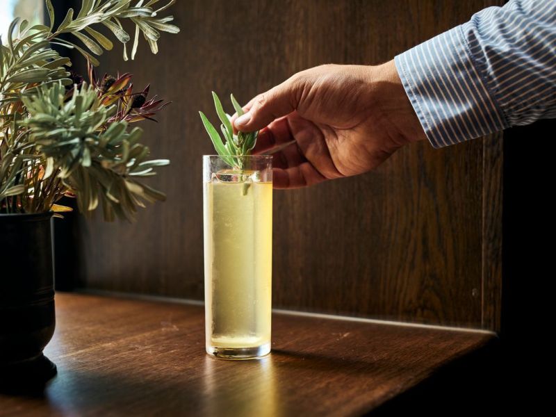 A man garnishes a whisky highball