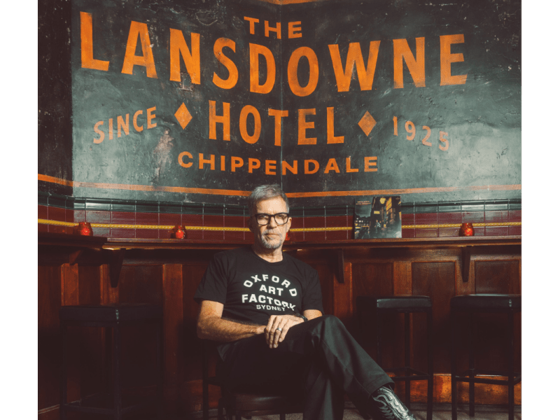 Mark Gerber sitting in front of a black and orange sign that readers 'the Lansdowne Hotel'